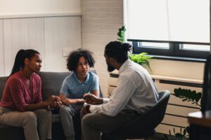 African American woman with teen son have a meeting with psychologist. A psychotherapist session with a patient. mother seeks professional help for her teenage son