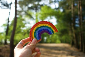 Bright coloured rainbow art created by children representing hope, health, happiness and family of LGBTQ rights. Sunny day denoting health and love. NHS Rainbow symbology during the COVID-19 pandemic.